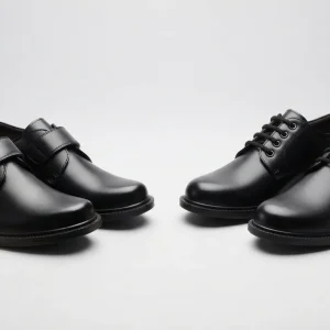 Pair of classic black formal school shoes featuring lace-up and Velcro strap designs with durable synthetic leather upper and comfortable cushioned sole for everyday school wear.