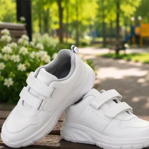 Kids white school sports sneakers with dual Velcro straps, cushioned sole, breathable lining, and anti-slip rubber outsole for everyday wear.