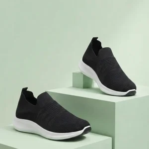 Men's black slip-on sneakers with breathable knitted mesh upper, lightweight cushioned white sole, and anti-slip outsole, worn for comfortable walking, travel, office, and everyday casual use.