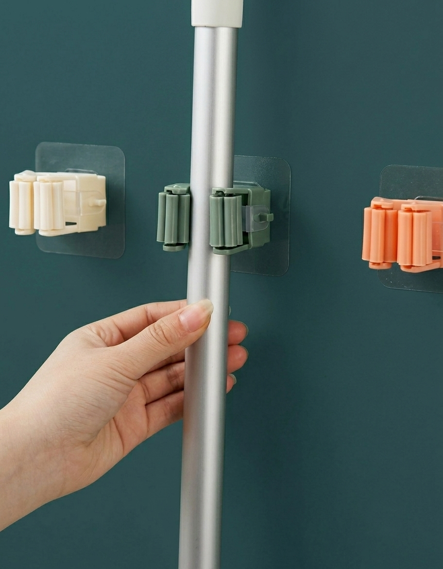 Self-adhesive wall mounted mop holder with non-slip roller grip securely holding a mop handle, ideal for organizing brooms and cleaning tools.
