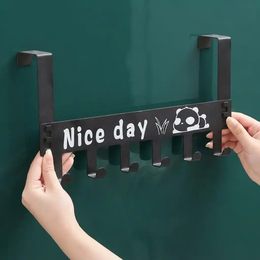 Black metal over-the-door hook hanger featuring six hooks and a panda Nice Day graphic being placed on a door.