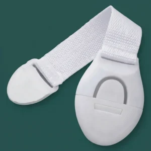 Flexible white adhesive child safety locks mounted on green cabinet doors and drawers to demonstrate corner installation and locking mechanism.