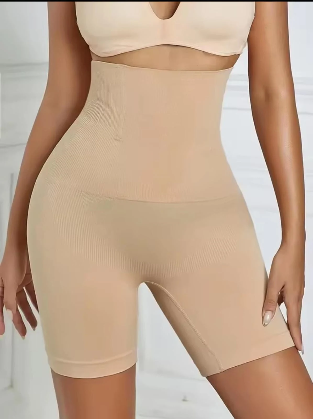 Two models wearing nude beige high waist tummy control shapewear shorts demonstrating waist slimming and butt lifting effect on green background