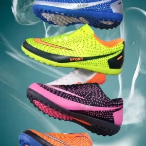 Stack of vibrant men's turf soccer shoes in royal blue, neon yellow, bright pink, and fiery orange with textured uppers and rubber studded outsoles