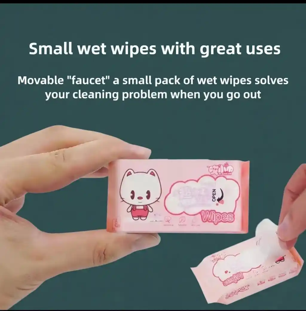 Hands holding a cute pink pocket sized mini wet wipes pack featuring a cartoon cat mascot for travel and kids face cleaning